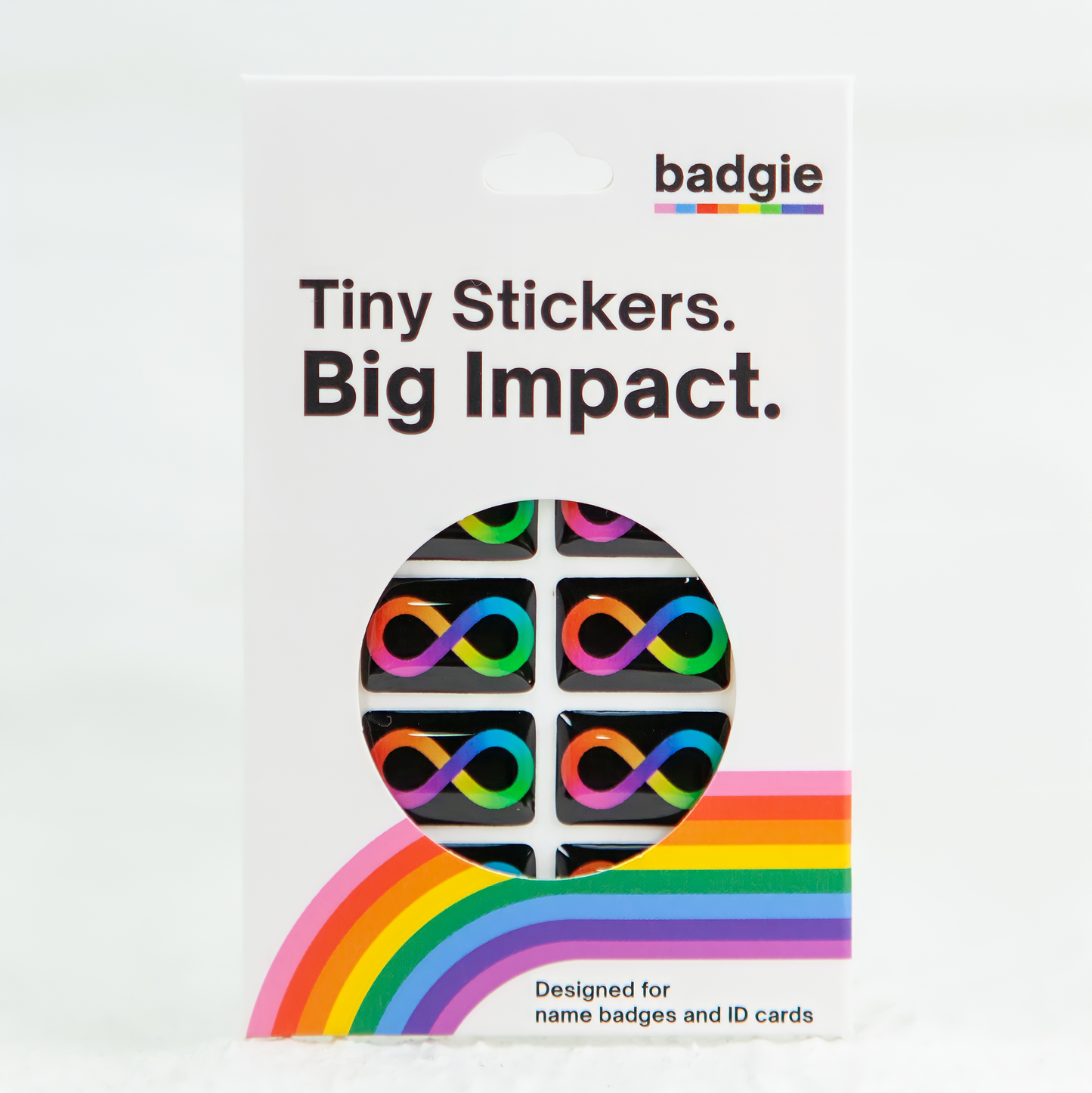 The retail packaging for the Badgie Neurodivergent Sticker, with a rainbow infinity loop design, showcasing the epoxy resin finish and high-quality details.