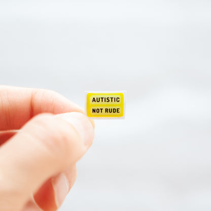 A sticker with the message 'Autistic Not Rude' designed for name badges and ID tags. A high-quality autistic sticker with a bright yellow background! Proudly say, I have autism!