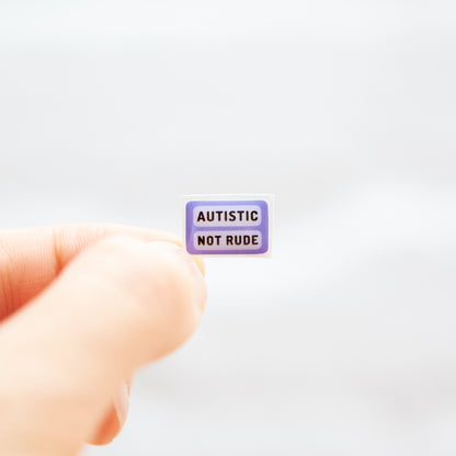 A sticker with the message 'Autistic Not Rude' designed for name badges and ID tags. A high-quality autistic sticker with a bright lavender purple background! Proudly say, I have autism!