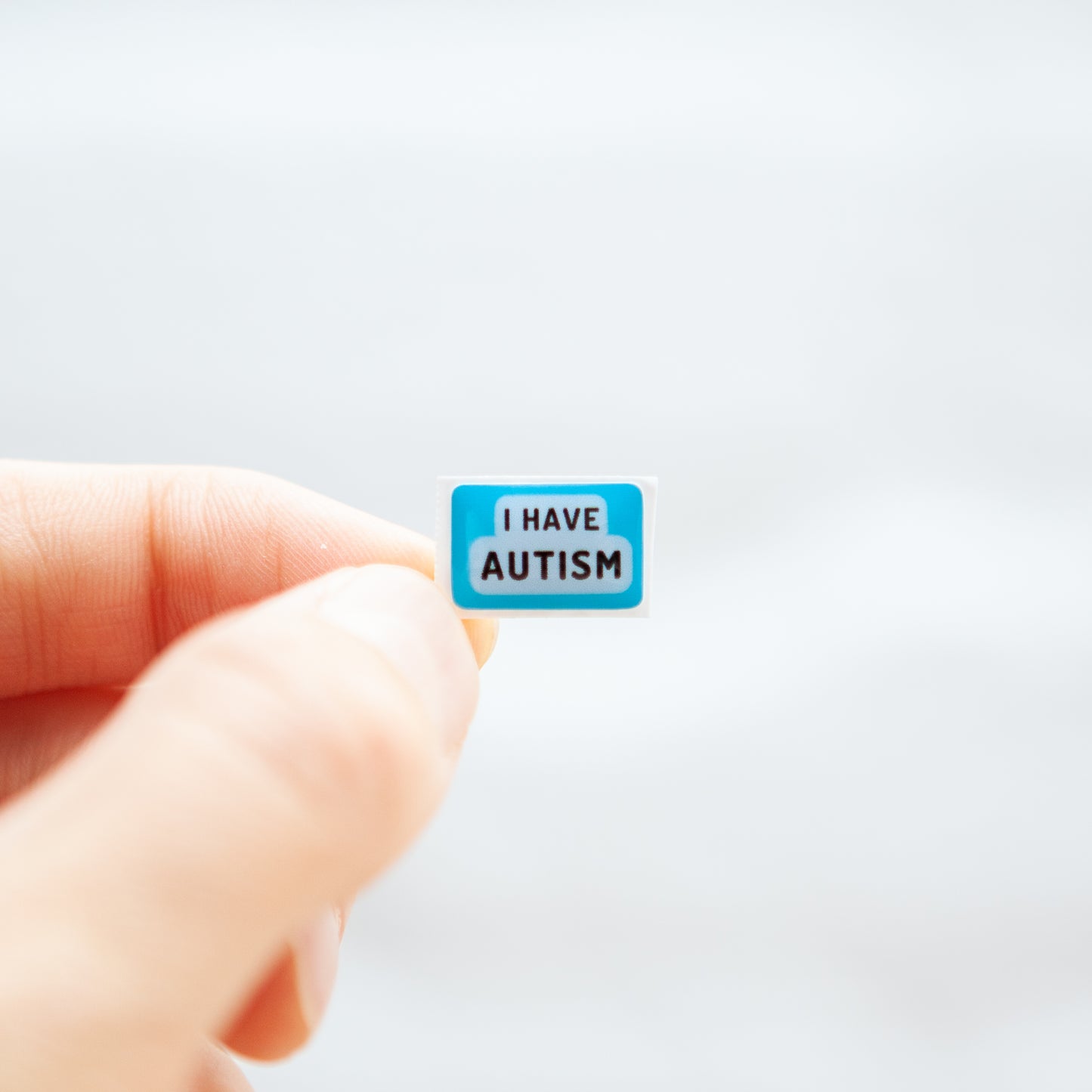 A high-quality autistic sticker with bold text saying "I Have Autism" in pink or blue, designed for name badges and ID badges, promoting autism awareness and inclusivity.