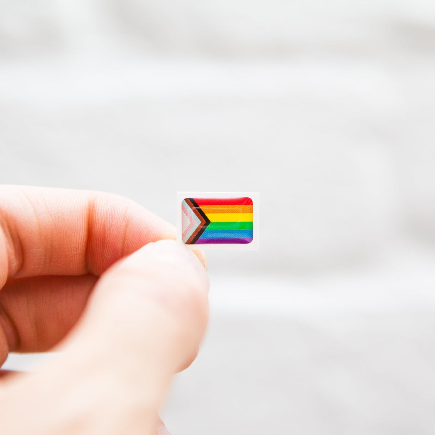 A Progress Pride Flag sticker designed for name badges and ID tags, representing the LGBTQIA+ community. A high-quality, durable gay pride LGBT sticker for inclusivity.