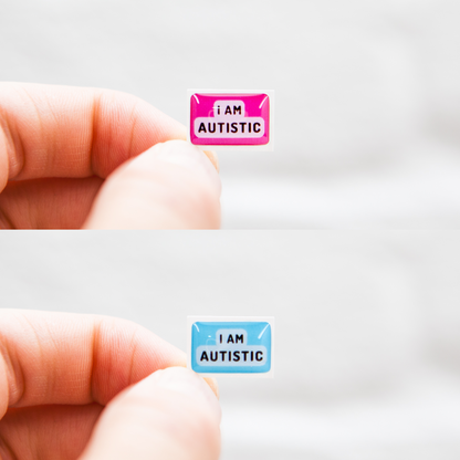A high-quality autistic sticker with bold text saying "I Am Autistic" in pink or blue, designed for name badges and ID badges, promoting autism awareness and inclusivity. 