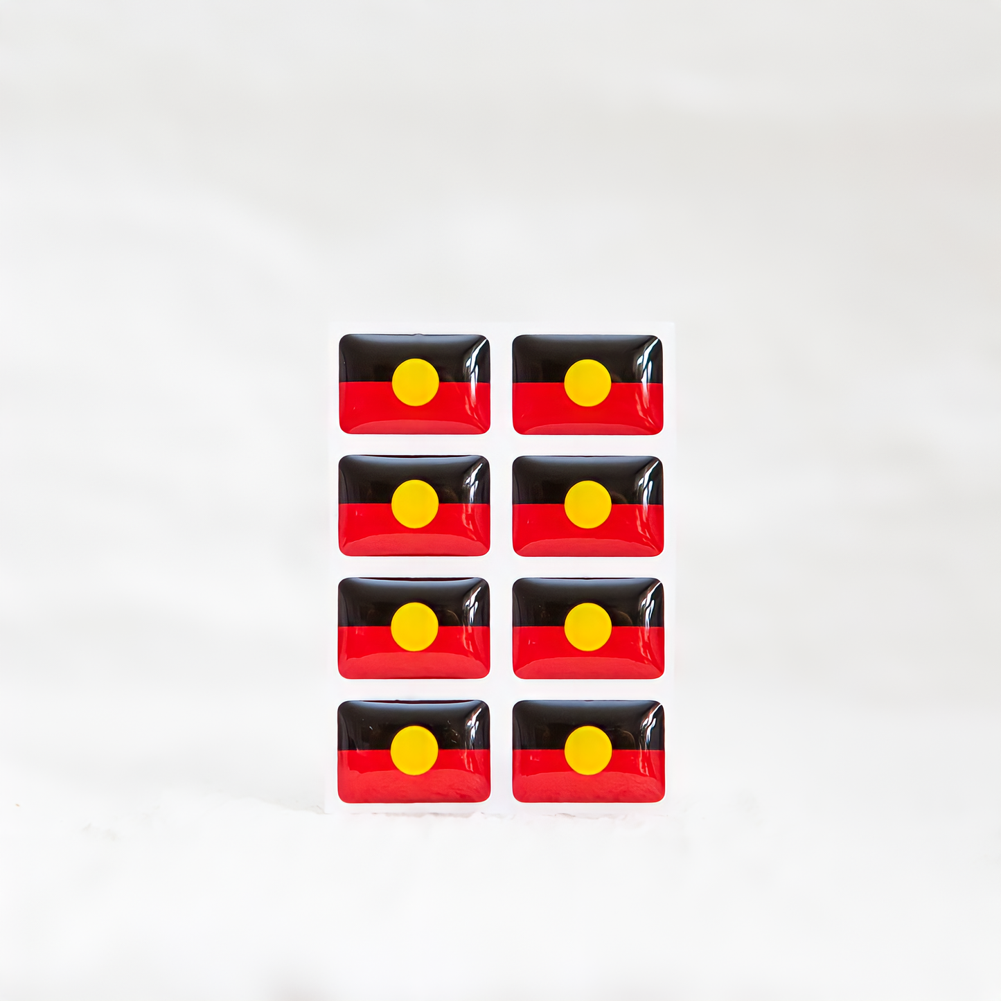 Badgie Aboriginal Flag Sticker. Always Was Always Will Be Aboriginal Land - Bright, durable sticker designed for name badges and ID tags, supporting Aboriginal and Torres Strait Islander peoples. Eight stickers.