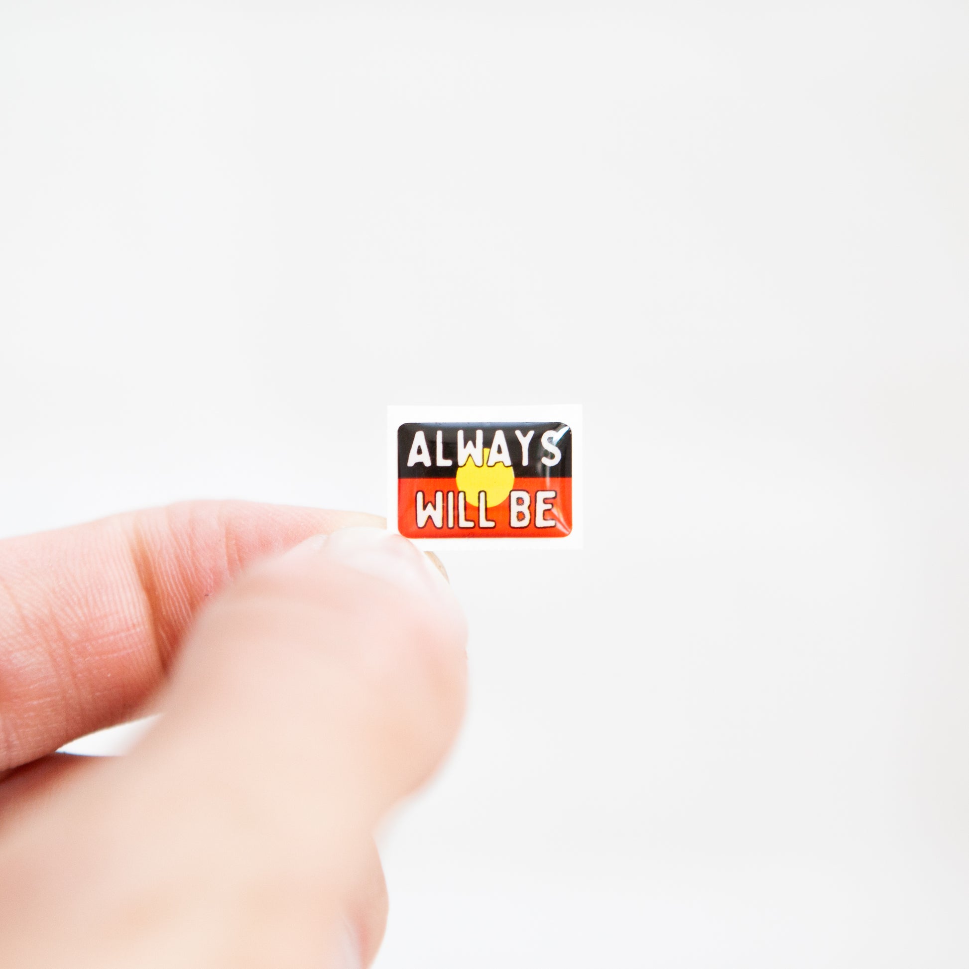 Badgie Always Will Be Aboriginal Land Sticker - Small, durable epoxy resin sticker with bright colors, designed for name badges and ID tags to support Aboriginal and Torres Strait Islander peoples.