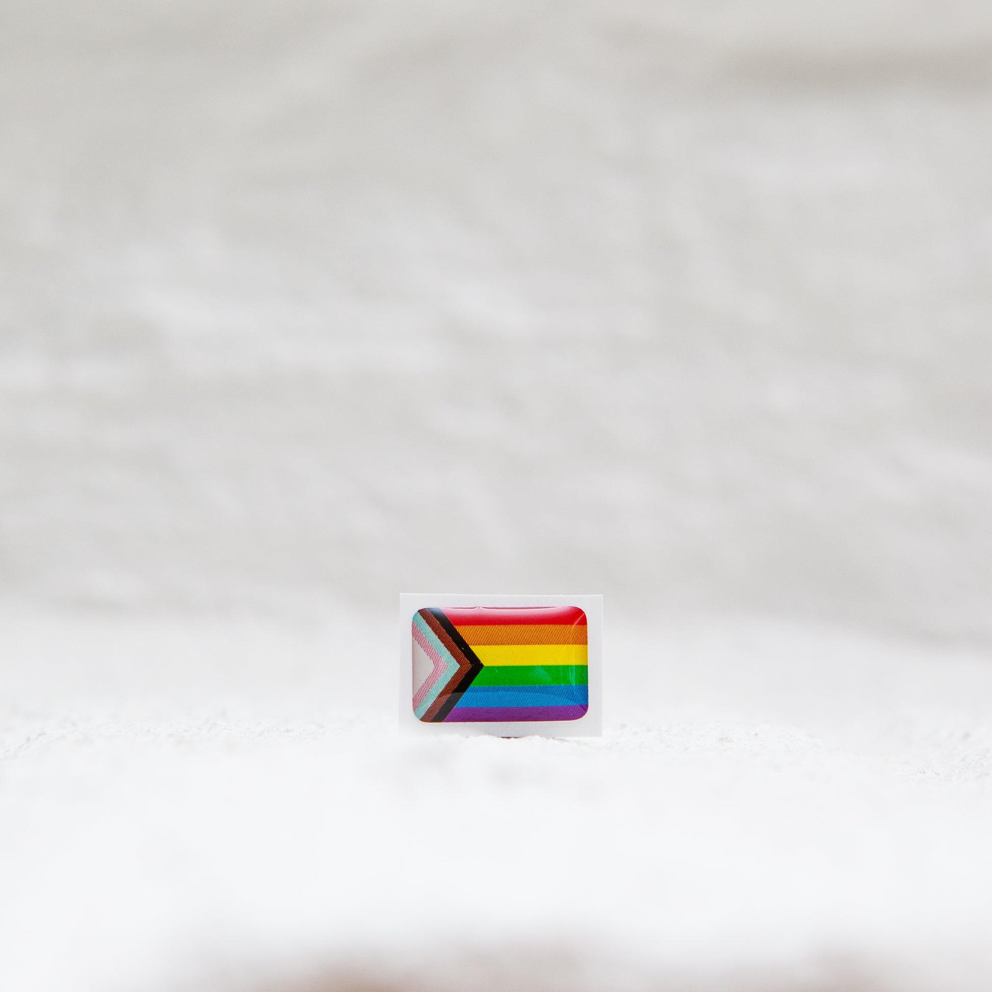 A Progress Pride Flag sticker designed for name badges and ID tags, representing the LGBTQIA+ community. A high-quality, durable gay pride LGBT sticker for inclusivity.