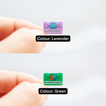 Fingers holding a green sticker and a lavender sticker, both with 'Neurodivergent' text, and a digitally illustrated image of a brain, representing neurodivergent stickers. Text underneath each sticker to identify the colours.